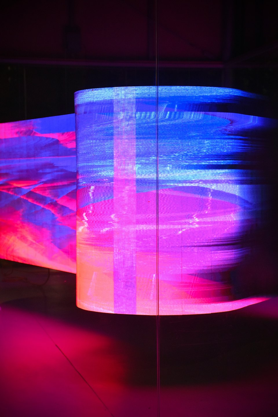 Zwei große digitale Bildschirme, die bunte Glitch-Art anzeigen.